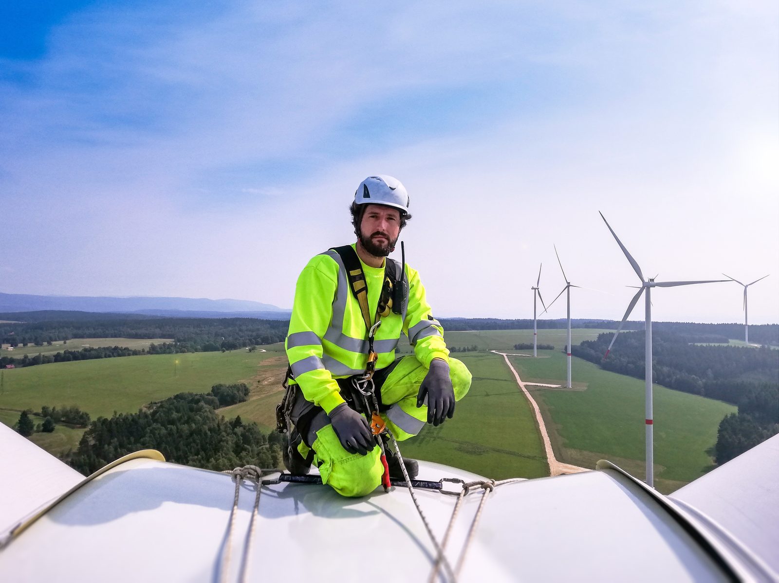 Arbeitssicherheit in luftiger Höhe: Fachkraft bei Höhenarbeiten an einer Windkraftanlage